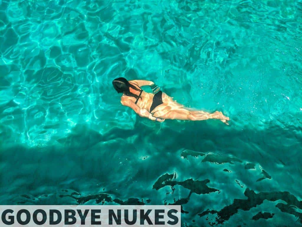 woman in black bikini swimming on clear blue water