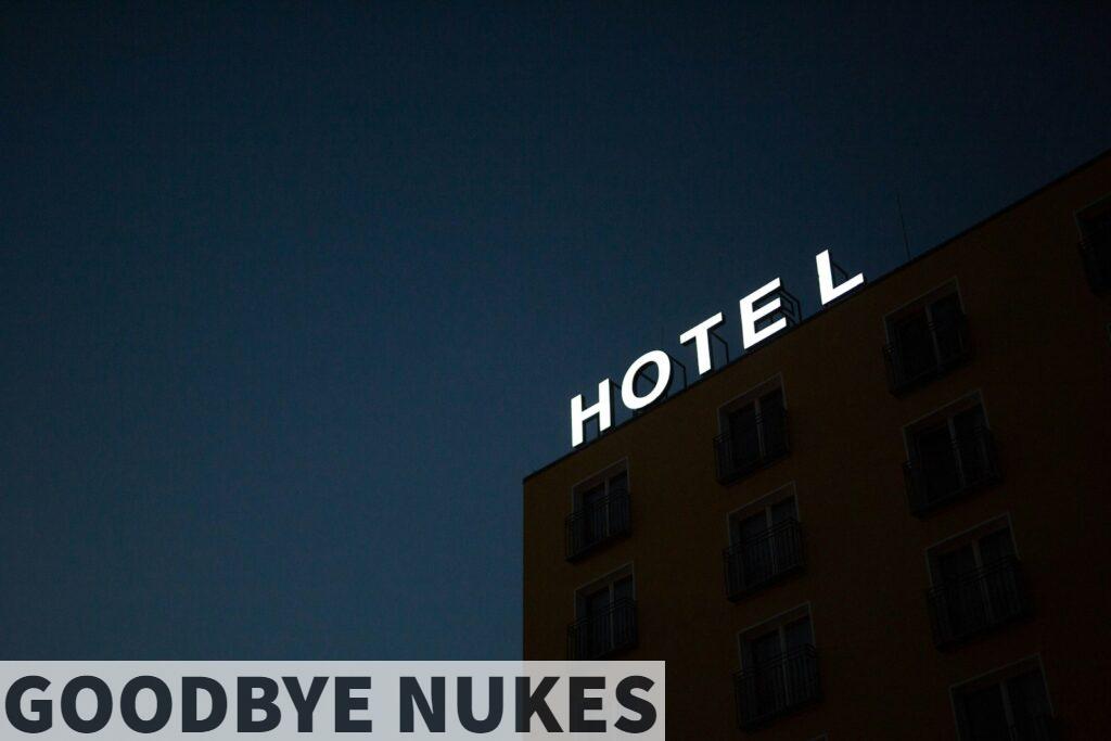low-angle photo of Hotel lighted signage on top of brown building during nighttime